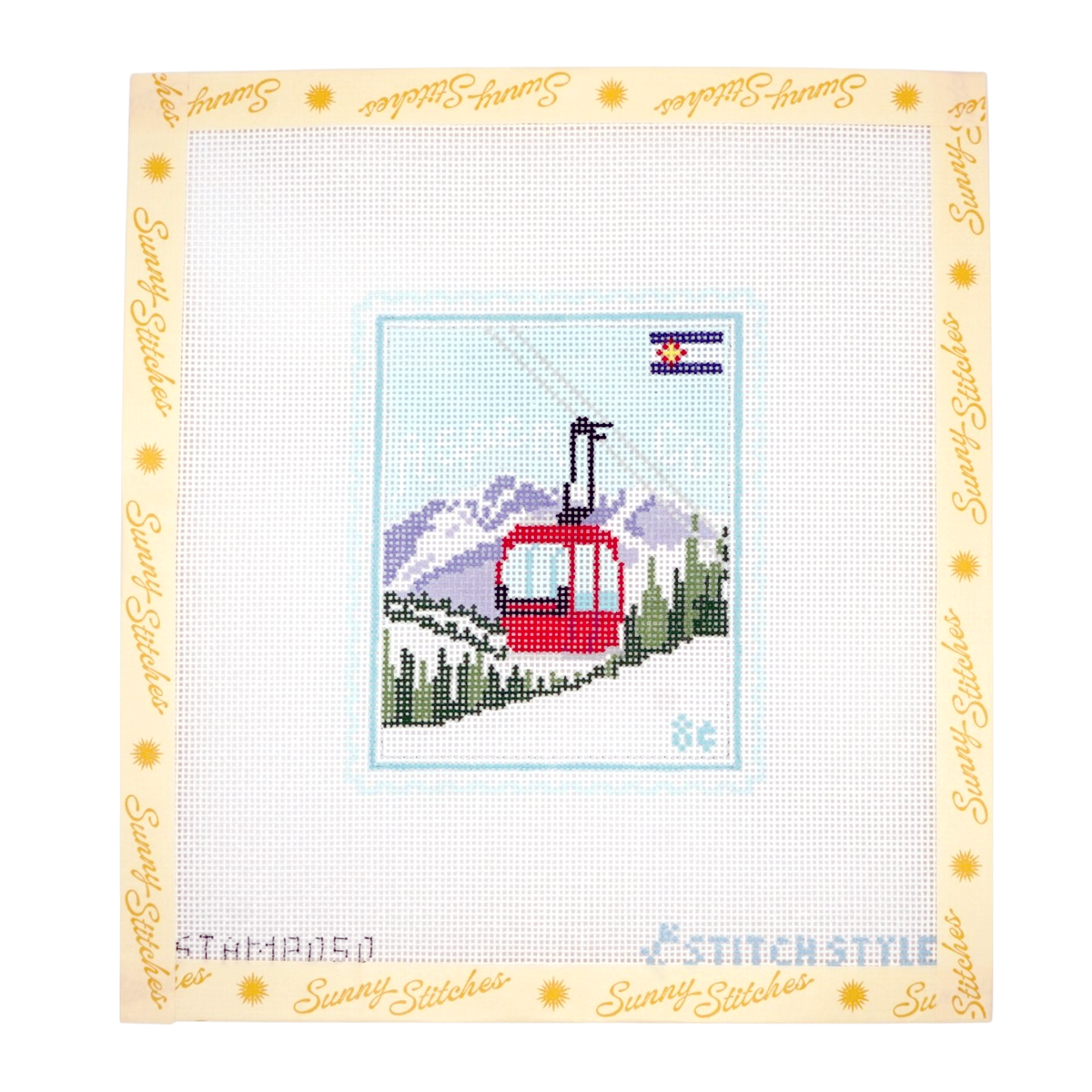 A needlepoint canvas featuring a red gondola on a mountain slope with pine trees and a mountain range under a Colorado state flag. The canvas is framed by a decorative border with the brand name 'Sunny Stitches' repeated in gold script on a cream background.