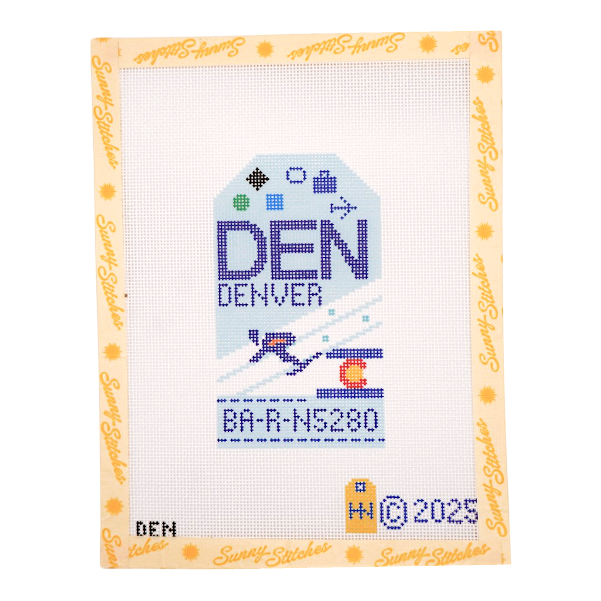 A cross-stitch canvas featuring a Denver tag design with the text 'DEN' and 'Denver' in blue, white, and purple, bordered by a yellow 'Suny Stitcher' brand margin.