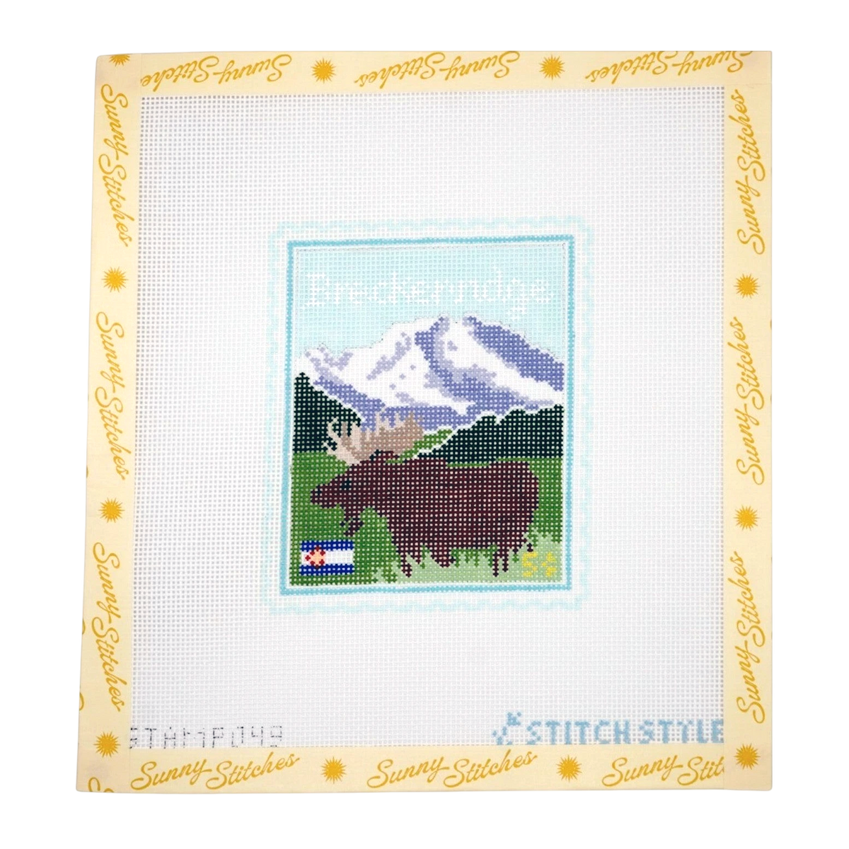 A square needlepoint canvas from Sunny Stitches featuring a cross-stitched design of a moose in front of mountains with the word 'Breckenridge' above it. The canvas has a pale yellow border printed with 'Sunny Stitches' and includes 'Stamp One' branding at the bottom.