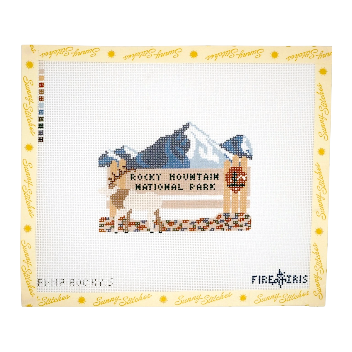 A cross-stitch piece featuring a mountain landscape with the text 'ROCKY MOUNTAIN NATIONAL PARK' and two deer, framed by a yellow border printed with 'Sunny Stitches.' 