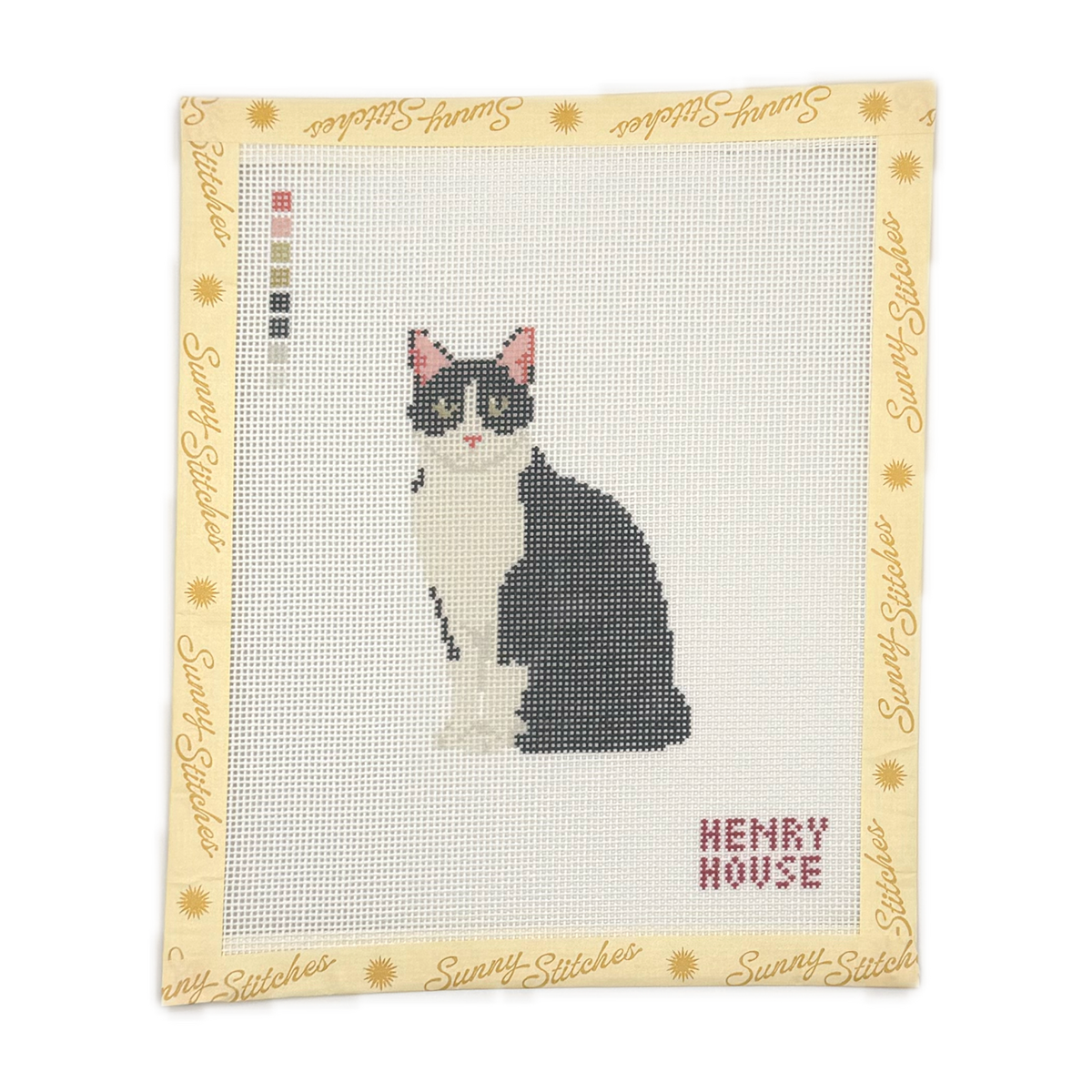 A square needlepoint canvas featuring a pixelated black and white cat with pink ears and eyes, surrounded by a decorative border with the brand name 'Sunny Stitches' and the words 'Happy Cat'.